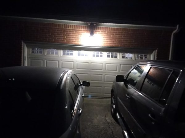 Closed double garage door on a brick home at night with both cars in the driveway after an after-hours repair in Portsmouth