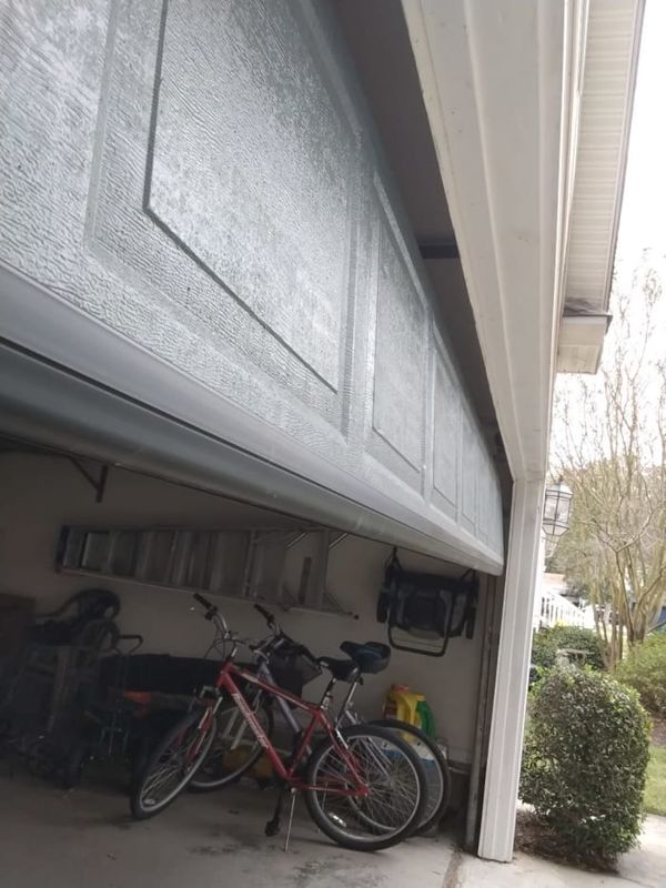 Raised 16-foot steel garage door showing the new bottom rubber seal installed along its base, Red Mill, Virginia Beach 23456, October 2026.