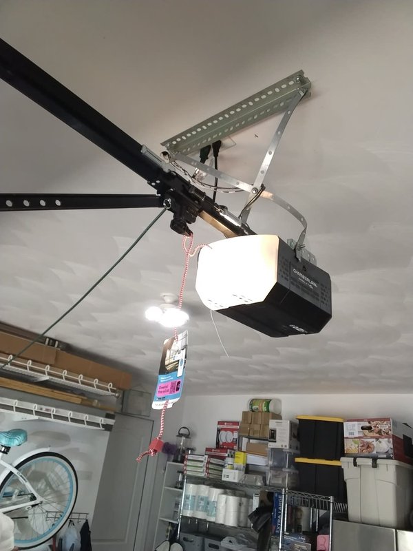 New Chamberlain belt-drive garage door opener mounted and wired on the ceiling rail, after installation, in a Cape Charles, Virginia garage
