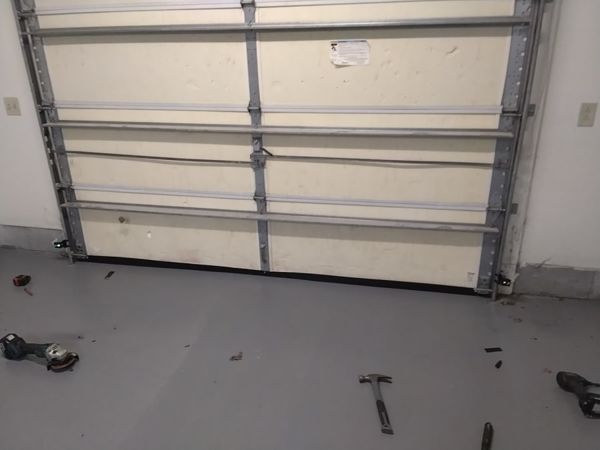 Garage door bottom seal replacement in Virginia Beach: a single-car door closed with new rubber bottom seal sitting flat on the garage floor, August 2026