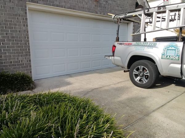 Garage door installation in Virginia Beach: new white 16x7 steel raised-panel door on a brick home in ZIP 23456, August 2026