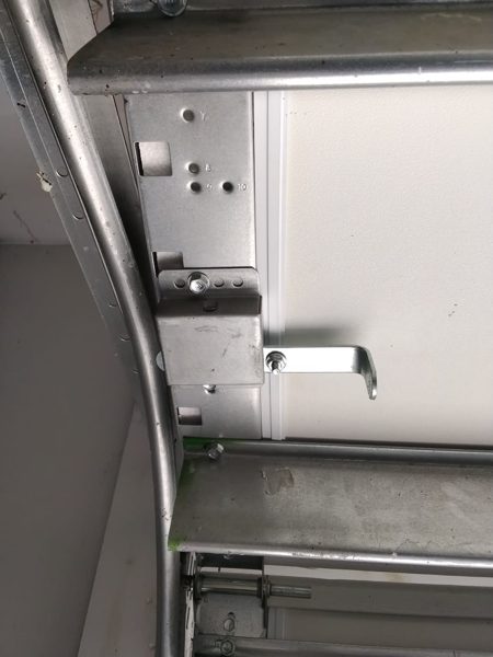 Garage door manual slide lock beside the track on a door that also has an opener, the line a home inspection flagged on a Suffolk house