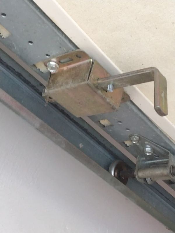 Garage door off track repair in Kempsville, Virginia Beach: the manual slide lock on the top section sits right beside the track, with a roller and hinge below it
