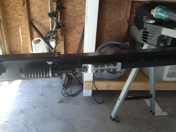 Garage door opener installation in Virginia Beach: the opener rail and belt on a sawhorse mid-job while they were shortened to fit between the wall and the attic opening