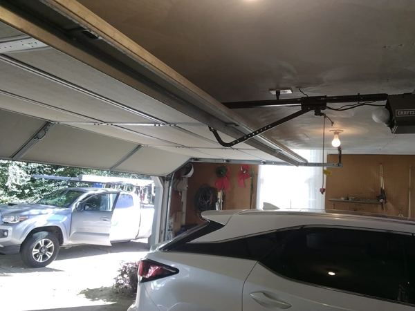 Garage door repair in Kempsville, Virginia Beach: a two-car garage door sitting crooked in its tracks under a Craftsman opener, October 26, 2026.