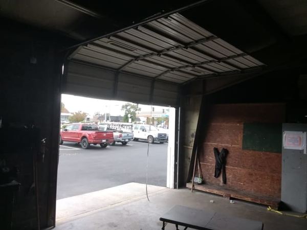 Black ribbed commercial garage door back on its tracks and closed in Portsmouth, VA 23704, October 12, 2026
