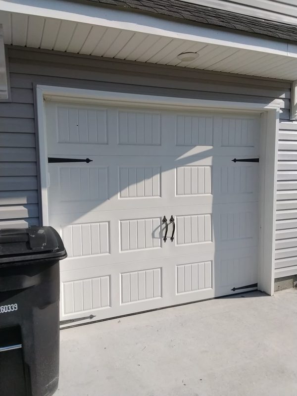 Single-car carriage-style garage door in Portsmouth, Virginia before the garage door trim (doorstop molding) replacement, September 2026