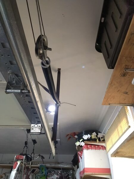 A new extension spring, pulley and safety cable installed along a garage door track in Portsmouth, Virginia