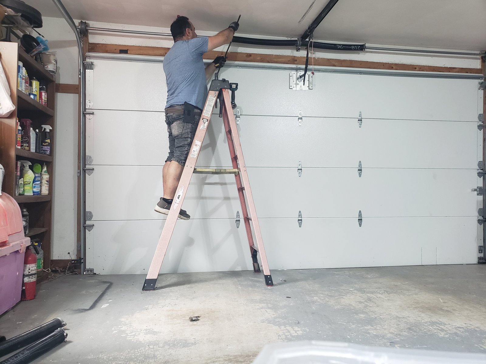 Heavy-gauge struts and reinforced hinges on a wind-rated garage door, the engineered hardware insurers want documented