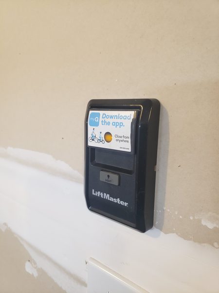 Technician testing a dead garage door opener wall console after a power surge in Tabb, York County 23693