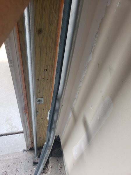 Seaside technician realigning a coastal Hampton Roads garage door track after a roller failure